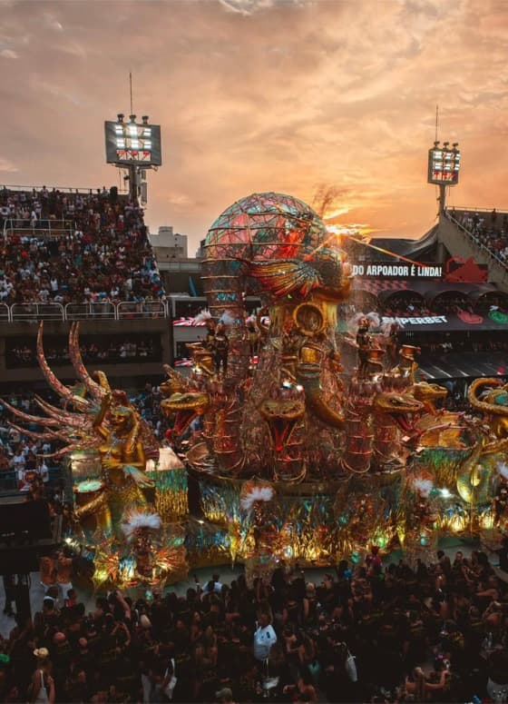 Carro alegórico em desfile de Carnaval ao entardecer